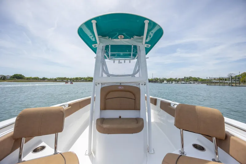 Slide: The Image of 2022 Sea Hunt Ultra 234 boat interior with tan seating on a sunny day. - 17