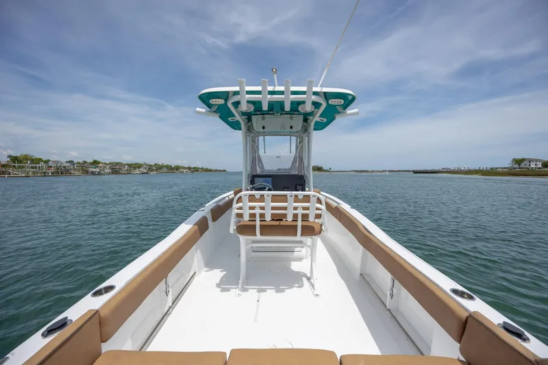 Slide: The Image of 2022 Sea Hunt Ultra 234 boat on calm water under a clear sky. - 8