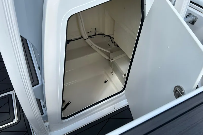 Slide: The Image of 2022 Bayliner Trophy T20CX boat storage compartment with open door, showcasing interior space. - 16