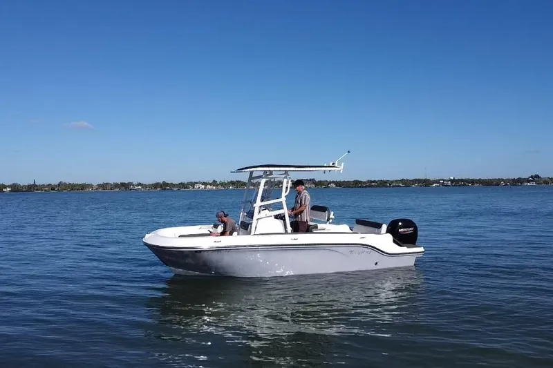 Slide: The Image of 2022 Bayliner Trophy T20CX boat on calm water under clear blue sky. - 20