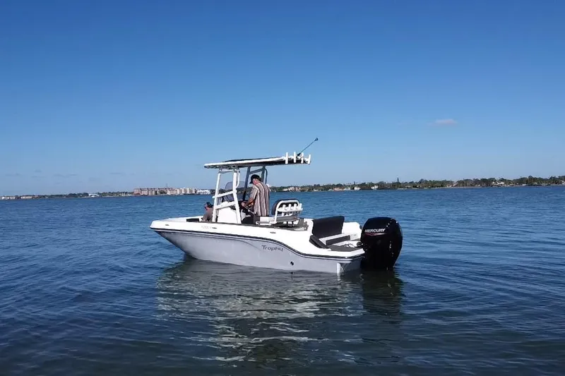 Slide: The Image of 2022 Bayliner Trophy T20CX boat on calm water under clear blue sky. - 21