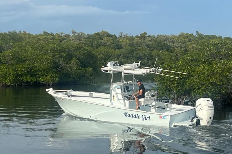 Slide: The Image of 2022 Latitude Tournament Boats 25 navigating through calm waters near lush greenery. - 16