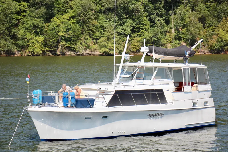 Slide: The Image of 1969 Hatteras 41 Double Cabin yacht cruising on a lake with people on deck. - 1