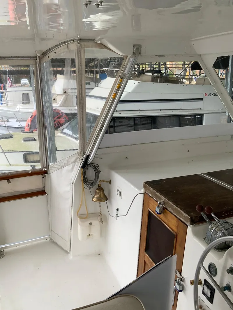 Slide: The Image of 1969 Hatteras 41 Double Cabin boat interior with steering wheel and wooden cabinetry. - 30