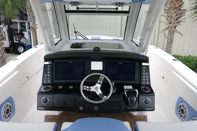 Slide: The Image of 2025 Robalo R360 Center Console boat dashboard with modern controls and steering wheel. - 16