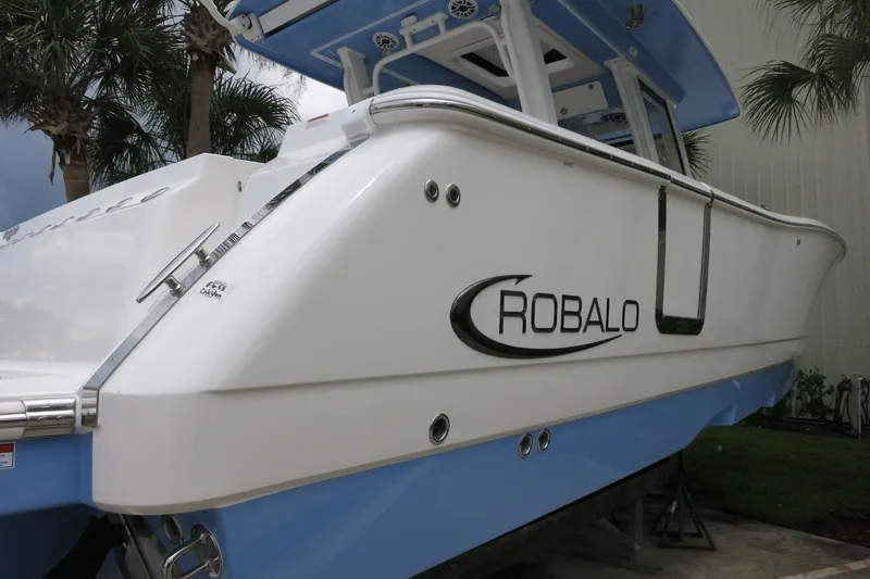Slide: The Image of 2025 Robalo R360 Center Console boat with sleek white and blue design. - 24