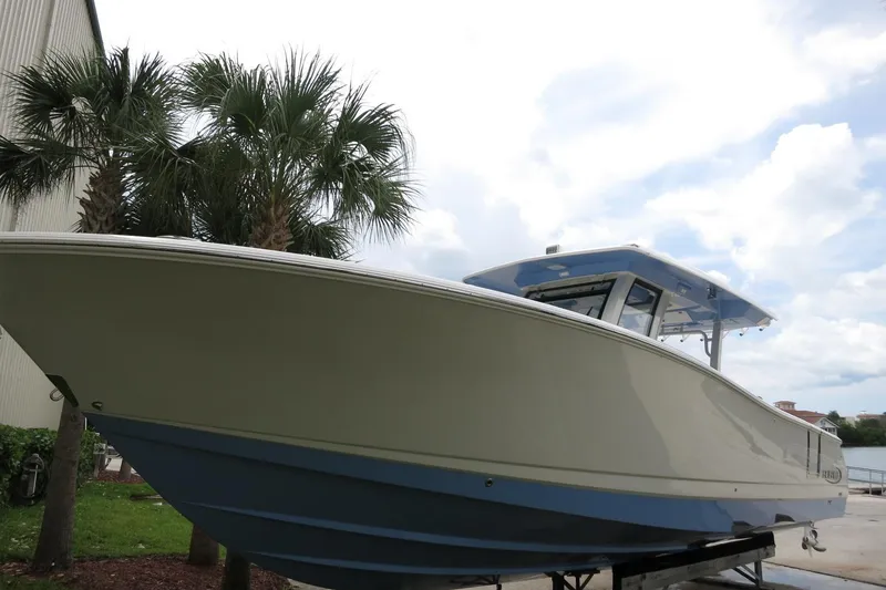 Slide: The Image of 2025 Robalo R360 Center Console boat displayed outdoors near palm trees. - 25