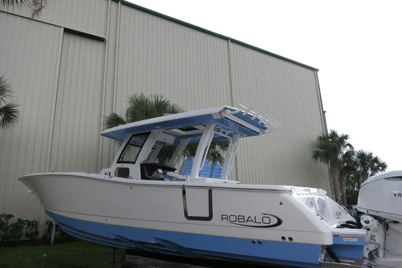 Slide: The Image of 2025 Robalo R360 Center Console boat displayed outdoors near a large building. - 3