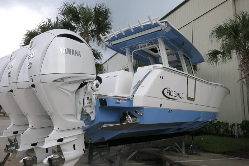 Slide: The Image of 2025 Robalo R360 Center Console boat with Yamaha engines, docked outdoors. - 6