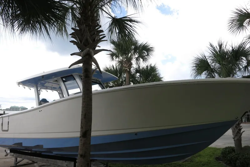 Slide: The Image of 2025 Robalo R360 Center Console boat displayed outdoors with palm trees. - 7