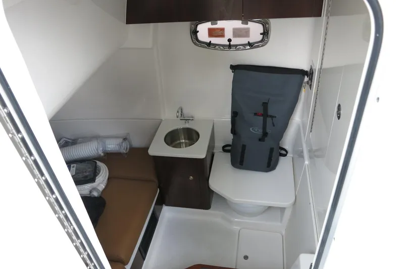 Slide: The Image of 2025 Robalo R360 Center Console cabin interior with sink and seating area. - 8
