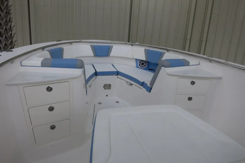 Slide: The Image of 2025 Robalo R360 Center Console boat interior with blue and white seating and storage compartments. - 9