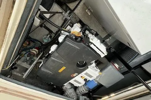 Slide: The Image of Engine compartment of a 1993 Mikelson 50 Sportfisher boat, showcasing mechanical components. - 18