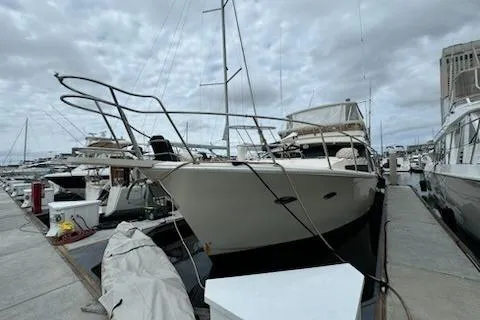 Slide: The Image of 1993 Mikelson 50 Sportfisher yacht docked at marina under cloudy sky. - 2