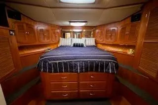 Slide: The Image of Luxurious cabin interior of 1993 Mikelson 50 Sportfisher with wood finish and cozy bedding. - 3