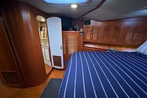 Slide: The Image of Interior of 1993 Mikelson 50 Sportfisher with wood paneling and striped bedding. - 4