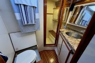 Slide: The Image of Bathroom interior of 1993 Mikelson 50 Sportfisher yacht with wood accents and granite countertop. - 6