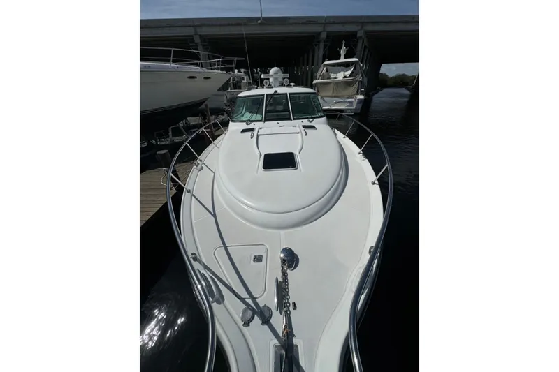 Slide: The Image of 2006 Tiara Yachts 4300 Sovran docked under a bridge, showcasing sleek design. - 4