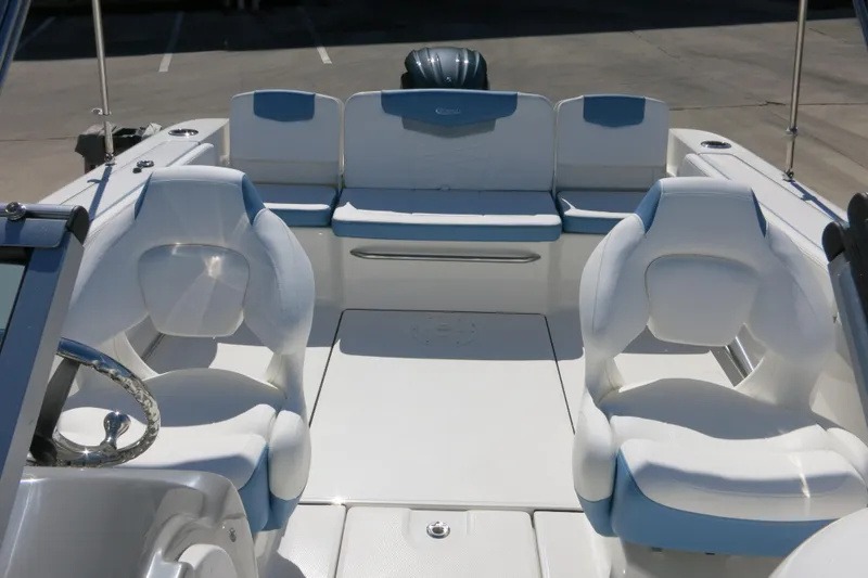 Slide: The Image of 2026 Robalo R207 Dual Console boat interior with white seating and steering wheel. - 18