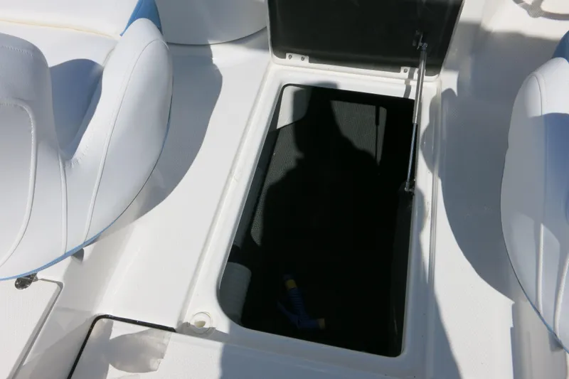 Slide: The Image of 2026 Robalo R207 Dual Console boat interior storage compartment with white seating. - 25