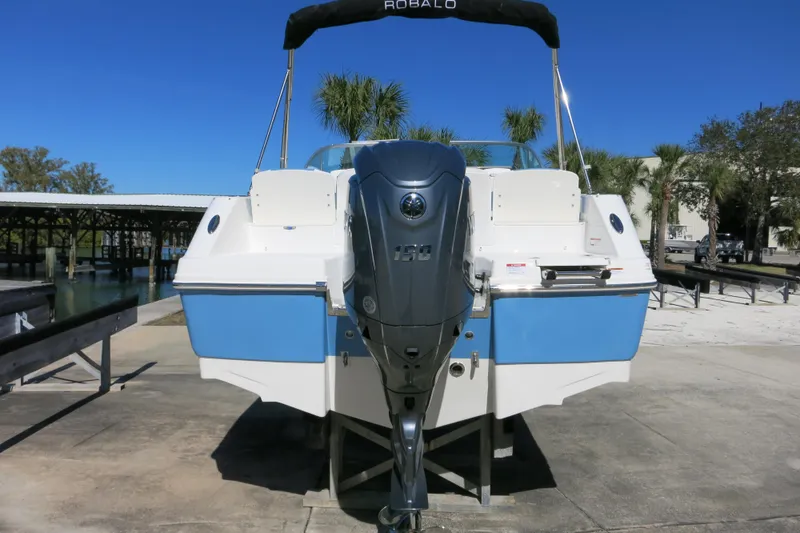 Slide: The Image of 2026 Robalo R207 Dual Console boat with powerful outboard motor, docked under clear blue sky. - 3