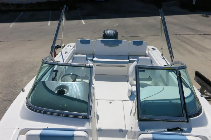 Slide: The Image of 2026 Robalo R207 Dual Console boat with open seating and windshield, parked on concrete. - 9