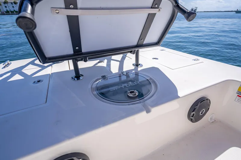 Slide: The Image of 2026 Spyder FX19 Vapor boat deck with storage compartment and speaker, on calm water. - 24