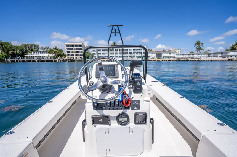 Slide: The Image of 2026 Spyder FX19 Vapor boat dashboard with steering wheel, on a sunny waterfront. - 25