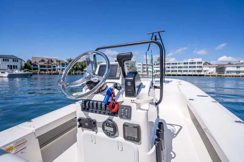 Slide: The Image of 2026 Spyder FX19 Vapor boat console with steering wheel, on a sunny waterfront. - 27