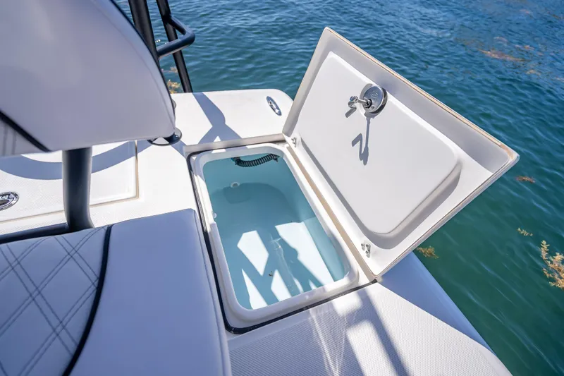 Slide: The Image of Open storage compartment on 2026 Spyder FX19 Vapor boat by the water. - 33