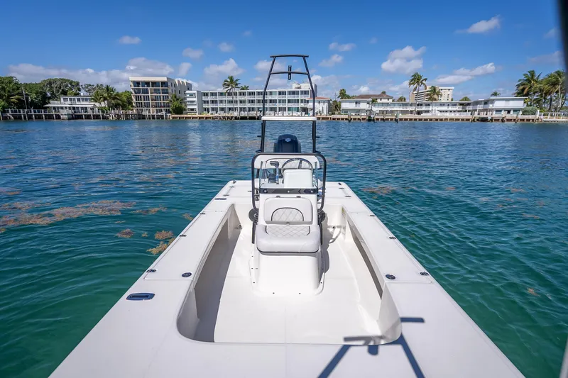 Slide: The Image of 2026 Spyder FX19 Vapor boat on clear blue water near modern waterfront buildings. - 37