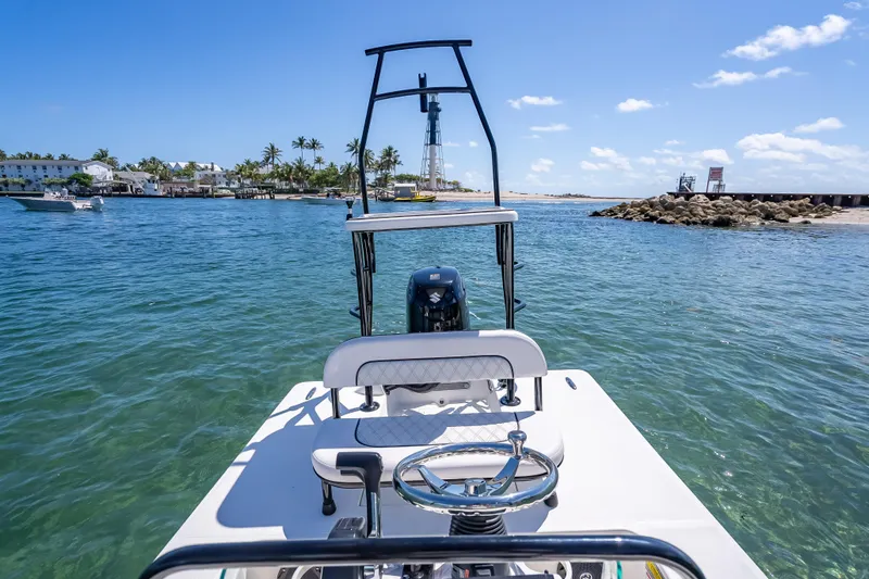 Slide: The Image of 2026 Spyder FX17 Flicker boat on clear blue water near a coastal town. - 32