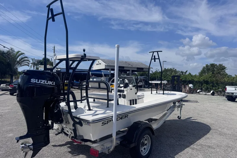 Slide: The Image of 2026 Spyder FX17 Flicker boat with Suzuki engine on trailer, parked outdoors. - 7