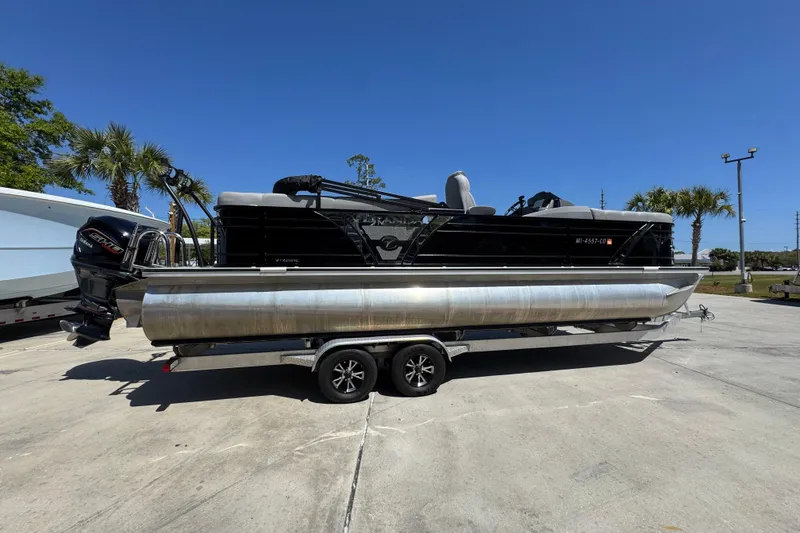 Slide: The Image of 2023 Veranda VTX 25RC pontoon boat on trailer, parked outdoors under clear blue sky. - 10