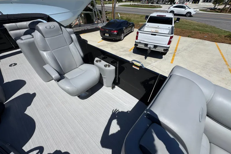 Slide: The Image of 2023 Veranda VTX 25RC boat interior with gray seating and cup holders in a parking lot. - 24