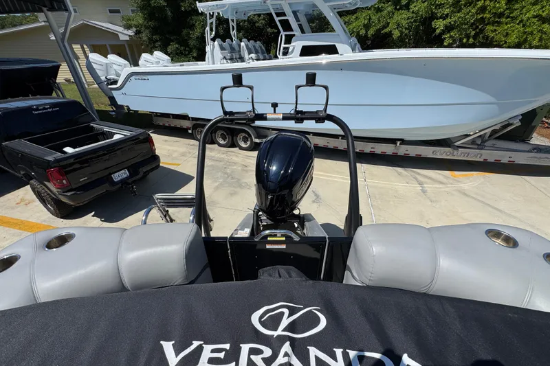 Slide: The Image of 2023 Veranda VTX 25RC pontoon boat with motor, parked near a trailer and truck. - 33