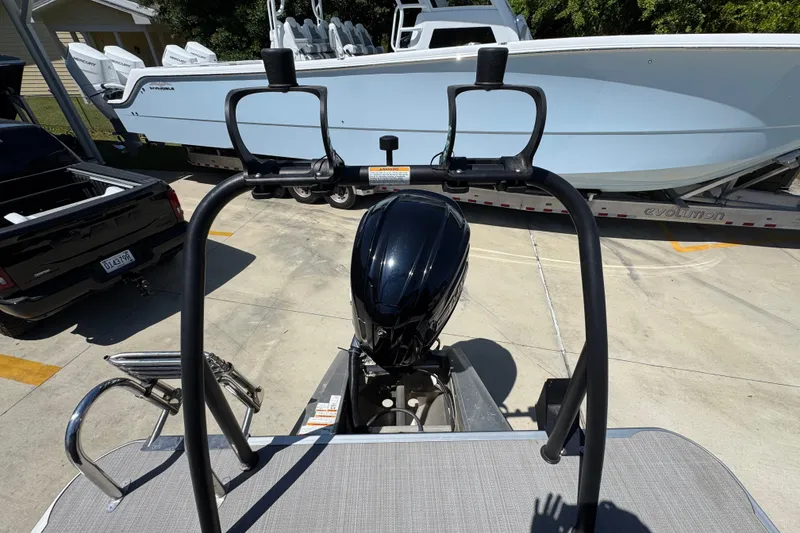 Slide: The Image of 2023 Veranda VTX 25RC pontoon boat with outboard motor, parked near a trailer. - 34