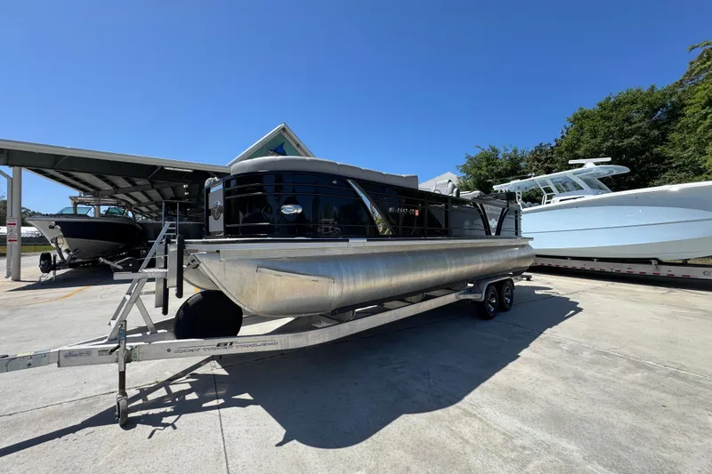 Slide: The Image of 2023 Veranda VTX 25RC pontoon boat on trailer under clear blue sky. - 4