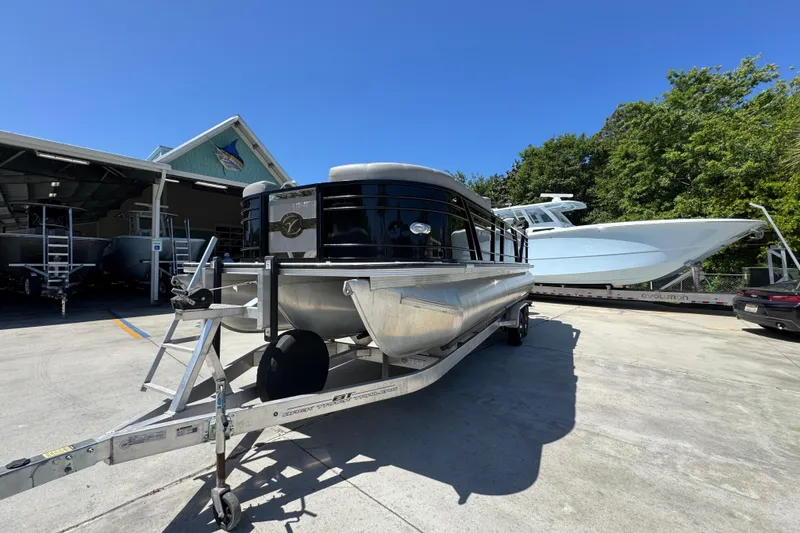 Slide: The Image of 2023 Veranda VTX 25RC pontoon boat on trailer, parked outdoors under clear blue sky. - 5