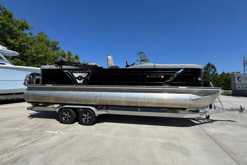 Slide: The Image of 2023 Veranda VTX 25RC pontoon boat on trailer, parked outdoors under clear blue sky. - 9