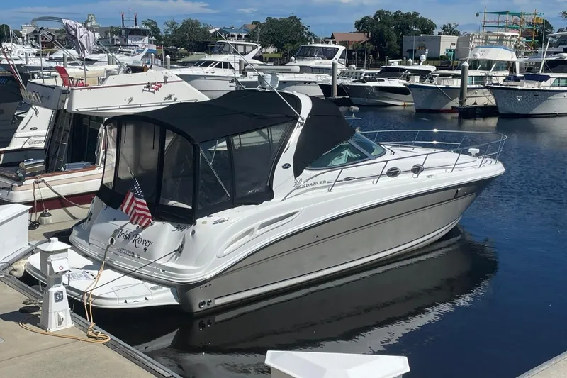 Slide: The Image of 2006 Sea Ray 360 Sundancer yacht docked at marina, featuring sleek design and American flag. - 4