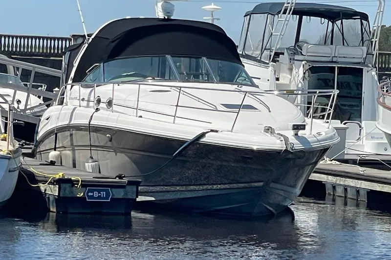 Slide: The Image of 2006 Sea Ray 360 Sundancer yacht docked at marina, featuring sleek design and black canopy. - 69