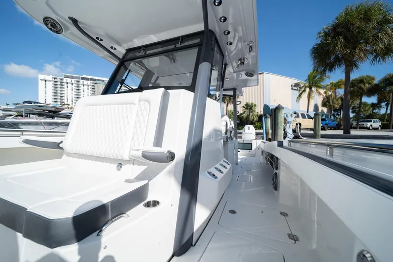 Slide: The Image of 2022 World Cat 400 CC-X boat with sleek design, docked near palm trees and buildings. - 14