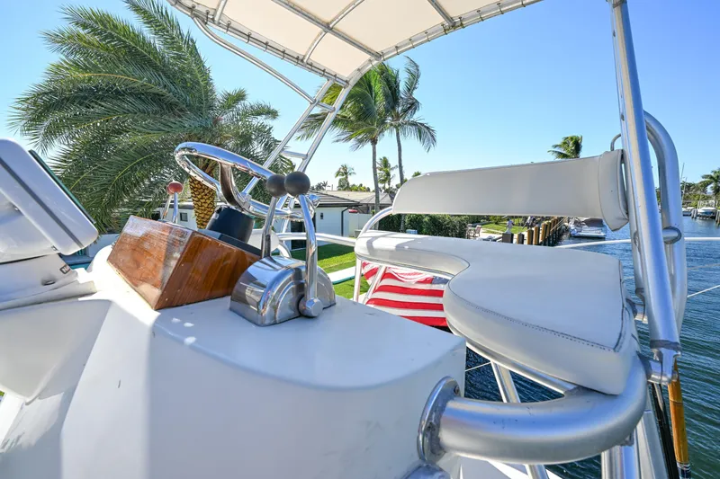 Slide: The Image of Helm of 2000 Pursuit 3400 Express boat with palm trees in background. - 16