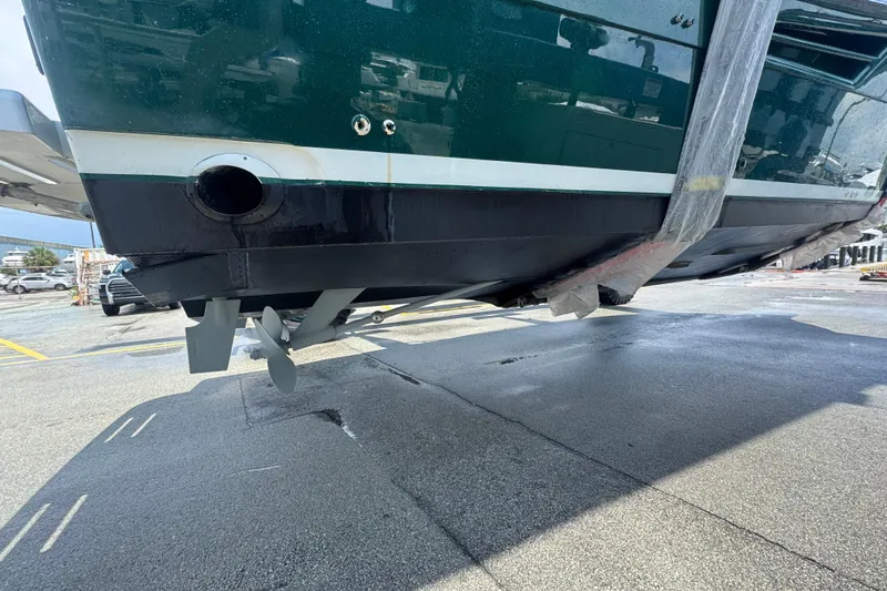 Slide: The Image of 2000 Pursuit 3400 Express boat hull and propellers during maintenance at a marina. - 60