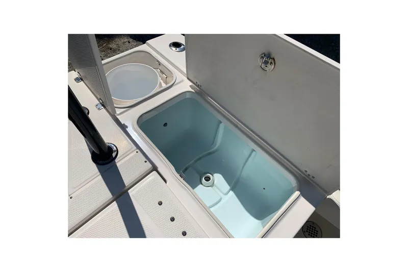 Slide: The Image of 2022 Robalo 246 Cayman boat storage compartment with open lid, showcasing interior space. - 11
