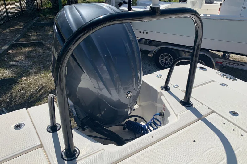 Slide: The Image of 2022 Robalo 246 Cayman boat engine with protective railing, parked on a trailer. - 13