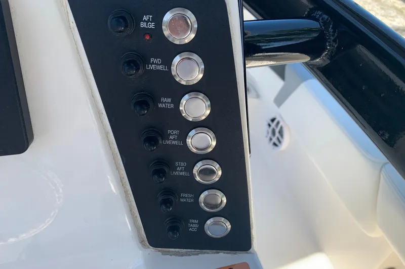 Slide: The Image of Control panel of a 2022 Robalo 246 Cayman boat with various switches. - 22