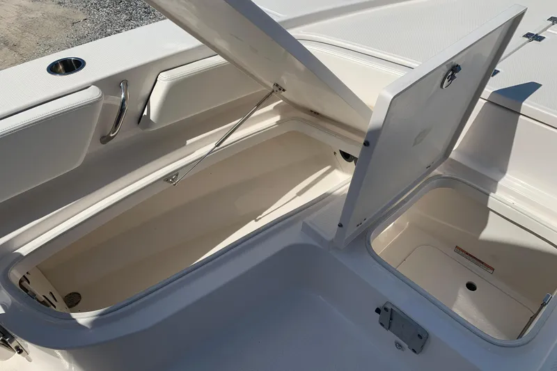 Slide: The Image of 2022 Robalo 246 Cayman boat storage compartments open, showcasing spacious interior design. - 29