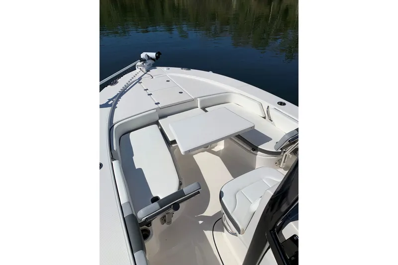 Slide: The Image of 2022 Robalo 246 Cayman boat interior with seating and table on calm water. - 35